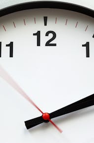 A close-up image of an analog clock face showing time with blurred motion